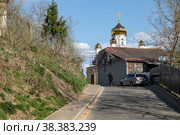 На одной из улиц подмосковного города Рузы в яркий солнечный весенний день. Городской пейзаж с видом на купола Воскресенского собора. Рузский район Московской области (2022 год). Стоковое фото, фотограф Наталья Николаева / Фотобанк Лори
