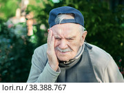 elderly person suffers from headaches, hypertension, stress, or migraines. a sick old man suffers from a headache, migraines . portrait in the background with a beautiful expressive senior. Стоковое фото, фотограф Оксана Медведева / Фотобанк Лори