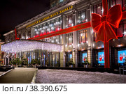 Christmas decoration of the Tsum store. Garlands, Christmas trees, a large red bow. Beautiful festive landscapes in the city of Moscow. Russia. (2017 год). Редакционное фото, фотограф Photojuli / Фотобанк Лори