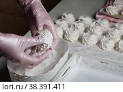 Homemade zephyr. White tray with marshmallows. A woman sprinkles marshmallows with dextrose. Стоковое фото, фотограф Vadzim Yakubovich / Фотобанк Лори
