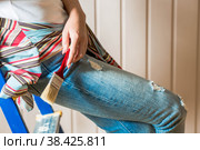 Женские руки крупным планом с малярной кистью. Внутренняя отделка дома, роспись стен. Косметический ремонт с использованием бежевой краски. Стоковое фото, фотограф Photojuli / Фотобанк Лори