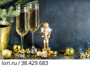 С Новым 2023 годом. Фон для рождественских и новогодних праздников с пространством для копирования. Игрушечный деревянный солдатик на рождественской елке и бокалы с шампанским на заднем плане. Стоковое фото, фотограф Photojuli / Фотобанк Лори