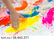 Счастливый веселый грязный ребенок играет с краской на белом фоне. Веселые развивающие игры дома. Грязные руки ребенка крупным планом. Стоковое фото, фотограф Photojuli / Фотобанк Лори
