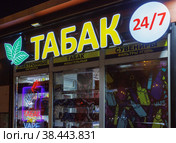 Ночная светящаяся вывеска "Табак 24/7" над зоной курения и круглосуточным киоском продаж (2022 год). Редакционное фото, фотограф Grigory_Gez / Фотобанк Лори