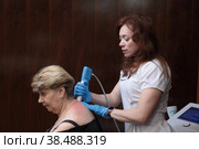 Доктор центра Бубновского в Балашихе разминает женщине воротниковую зону (2022 год). Редакционное фото, фотограф Дмитрий Неумоин / Фотобанк Лори