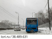 Электробус следует по маршруту №38 по Сущевской улице в городе Москве. Январская непогода, снегопад. Вид через мокрое лобовое стекло автомобиля (2021 год). Редакционное фото, фотограф Наталья Николаева / Фотобанк Лори