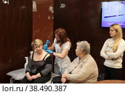 Доктор центра Бубновского в Балашихе разминает женщине воротниковую зону (2022 год). Редакционное фото, фотограф Дмитрий Неумоин / Фотобанк Лори