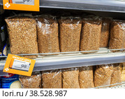 Buckwheat in a transparent bags on the shelf at the grocery store (2022 год). Редакционное фото, фотограф FotograFF / Фотобанк Лори