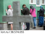 Россия. Санкт-Петербург. Верующие молятся у стены церкви. Паломники у часовни Святой Ксении Петербургской. Russia. Saint-Petersburg. Believers pray at the wall of the church. Pilgrims at the chapel of St. Xenia of St. Petersburg. (2017 год). Редакционное фото, фотограф Алексей Смышляев / Фотобанк Лори