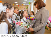 Россия. Санкт-Петербург. Школьники поздравляют учителя с началом учебного года первого сентября в День знаний. Russia. Saint-Petersburg. Students congratulate the teacher on the beginning of the school year on the first of September on the Day of Knowledge. (2021 год). Редакционное фото, фотограф Алексей Смышляев / Фотобанк Лори