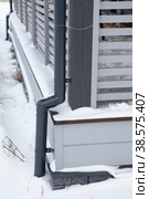Rainwater downpipe system for wooden veranda of cottage, frozen and covered with snow. Стоковое фото, фотограф Кекяляйнен Андрей / Фотобанк Лори