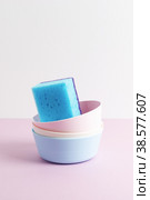 Blue cleaning sponge in colorful bowls on pink and white background. Стоковое фото, фотограф Юлия Трикашная / Фотобанк Лори