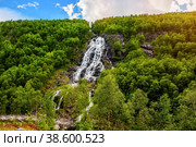Mountain landscape with a beautiful waterfall and cloudy sky . The beautiful nature of the Norwegian fjords.. Стоковое фото, фотограф Оксана Медведева / Фотобанк Лори