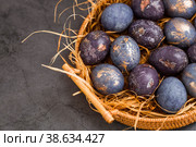 Easter card with a copy of the place for the text. Purple, blue and golden eggs on a dark background. The trend of 2022 purple shade is very peri. Natural dye karkade tea. Top view. Стоковое фото, фотограф Photojuli / Фотобанк Лори