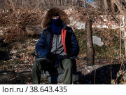 A grown man in a mask, in a jacket with a hood, in military trousers, in gloves rests in a machine gun in his hands. Стоковое фото, фотограф Владимир Арсентьев / Фотобанк Лори