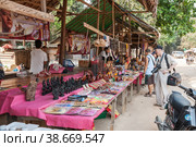 Cambodian souvenirs. Tourists choose gifts and souvenirs at a street market near local attractions in Phnom Kulen National Park (2013 год). Редакционное фото, фотограф Юлия Бабкина / Фотобанк Лори