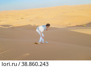 Young men sand surfing at the sand dunes of Dubai United Arab Emirates. Стоковое фото, фотограф Fokke Baarssen / Фотобанк Лори