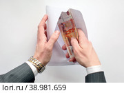 Концепт коррупции. Взятка. Чиновник достаёт деньги из конверта. Стоковое фото, фотограф Александр Тарасенков / Фотобанк Лори