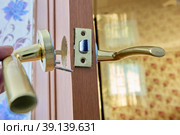 Alignment of lever door handle with latch during installation. Стоковое фото, фотограф Владимир Григорьев / Фотобанк Лори