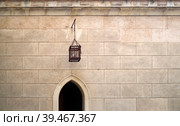 Wall of a medieval Bojnice Castle (Slovakia) with an Arrowslit and the skull of a decapitated criminal. Isolated background. Стоковое фото, фотограф Елена  Попкова / Фотобанк Лори