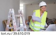 Female foreman in a protective helmet and a yellow vest checks the execution of repair work using a laptop. Стоковое видео, видеограф Яков Филимонов / Фотобанк Лори
