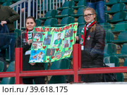 Молодые девушки-болельщицы клуба "Локомотив" с плакатом в поддержку игрока во время футбольного матча полуфинала Кубка России по футболу "Локомотив" (Москва) - "Ростов" (Ростов-на-Дону), стадион "Локомотив" Москва, Россия (2019 год). Редакционное фото, фотограф Pukhov K / Фотобанк Лори