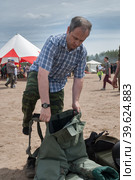 Man - visitor of show tries on the sapper suit (2016 год). Редакционное фото, фотограф Сергей Буторин / Фотобанк Лори