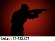 Silhouette of a military man with a rifle at night on a red background. Side view. Стоковое фото, фотограф Владимир Арсентьев / Фотобанк Лори
