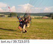 Мотопараплан с пилотом и пассажиром совершает взлёт. A paramotor with a pilot and a passenger takes off (2022 год). Редакционное фото, фотограф Евгений Романов / Фотобанк Лори