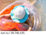 Girl in a hat swimming in the river with a transparent inflatable circle in the shape of a heart with orange feathers inside.The sea with a sandy bottom. Beach holidays, swimming, tanning, sunscreens. Стоковое фото, фотограф Ольга Симонова / Фотобанк Лори