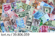 Top view on pile of money from different countries in paper banknotes of various denominations. Dollar, euro, pound, yuan, tugrik, ruble, won, baht are mixed on table. International cooperation concept. Money background. Стоковое фото, фотограф Виктория Катьянова / Фотобанк Лори