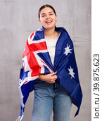 Joyous young woman holding Australia flag against unicoloured background. Стоковое фото, фотограф Яков Филимонов / Фотобанк Лори