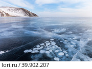 Beautiful winter landscape of frozen Baikal Lake in cold February day. Natural seasonal background with blue ice cover with white bubbles and cracks.  Winter ice travel and active outdoors. Стоковое фото, фотограф Виктория Катьянова / Фотобанк Лори
