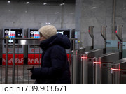 Женщина проходит турникеты в на входе на станцию Московского метрополитена в городе Москве, Россия (2023 год). Редакционное фото, фотограф Николай Винокуров / Фотобанк Лори