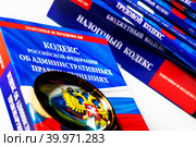 Увеличительное стекло и Кодекс Российской Федерации об административных правонарушениях на белом фоне (2023 год). Редакционное фото, фотограф Николай Винокуров / Фотобанк Лори