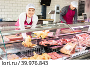 Young woman puts chicken meat in showcase. Стоковое фото, фотограф Яков Филимонов / Фотобанк Лори