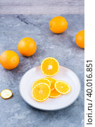 Pieces of fresh orange on a plate on the table. Vitamins, diet and vigor. Vertical view. Стоковое фото, фотограф Елена Руй / Фотобанк Лори