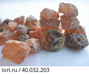 Pine rosin in crystal-like pieces of amber-caramel shades, soft dim light. Close-up of solid rosin in a pile, powder-coated small pieces of various shapes and sizes; hatching pencil imitation. Стоковое фото, фотограф Анатолий Власов / Фотобанк Лори