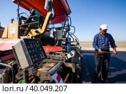 Kyzylorda province, Kazakhstan, April 29, 2012: Construction of West Europe-West China new highway. Dynapac road machine. Builder controls asphalt quality. Стоковое фото, фотограф Alexey Rezvykh / Фотобанк Лори