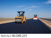 Kyzylorda province, Kazakhstan, April 29, 2012: Construction of West Europe-West China highway. Caterpillar and Hamm asphalt compactor flattens asphalt. Стоковое фото, фотограф Alexey Rezvykh / Фотобанк Лори