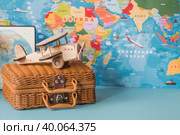 Туризм. Модель старинного самолета и чемодан на фоне карты мира. Концепция путешествий, приключений и открытий. (2023 год). Стоковое фото, фотограф Photojuli / Фотобанк Лори