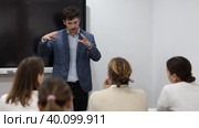 Experienced male teacher giving lecture to group of student Knowledgeable professor explaining subject to classroom full of students Competent male tutor teaching students in college classroom college. Стоковое видео, видеограф Яков Филимонов / Фотобанк Лори