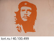 Одноцветное изображение латинского революционера Эрнеста Че Гевара оранжевого цвета на стене. Уличное граффити (2023 год). Редакционное фото, фотограф Sergei Gorin / Фотобанк Лори