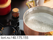 Copper pot with boiling water on a gas stove. Стоковое фото, фотограф Сергей Толмачёв / Фотобанк Лори