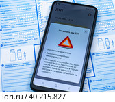 Смартфон с открытым приложением Госуслуги Авто на бланке извещения о ДТП (2023 год). Редакционное фото, фотограф Анна Аникова / Фотобанк Лори