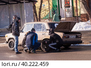 The driver with friends change the punctured wheel by car (2019 год). Редакционное фото, фотограф Сергей Буторин / Фотобанк Лори