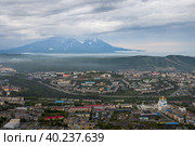 Город Петропавловск-Камчатский, Камчатский край, Дальний Восток России. Красивый городской пейзаж. Вид сверху на собор, здания и улицы. Вулканы вдалеке. Пасмурная погода. Низкая облачность. Стоковое фото, фотограф Андрей Степанов / Фотобанк Лори