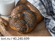 Классическая пшеничная коса или плетёнка с маком. Вкусный хлеб крупным планом. Свежеиспеченный хлеб на закваске с золотистой корочкой на деревянной доске. Контекст пекарни с вкусным хлебом. Кондитерские изделия. Стоковое фото, фотограф Photojuli / Фотобанк Лори