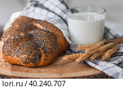 Классическая пшеничная коса или плетёнка с маком. Вкусный хлеб крупным планом. Свежеиспеченный хлеб на закваске с золотистой корочкой на деревянной доске. Контекст пекарни с вкусным хлебом. Кондитерские изделия. Стоковое фото, фотограф Photojuli / Фотобанк Лори