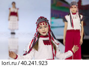 Девушки демонстрируют Удмутрский национальный костюм на подиуме в рамках шоу "Грани Мира" на фестивале детской моды Kids Fashion Week в "Центральном детском магазине на Лубянке" (ЦДМ) в Москве, Россия (2023 год). Редакционное фото, фотограф Николай Винокуров / Фотобанк Лори